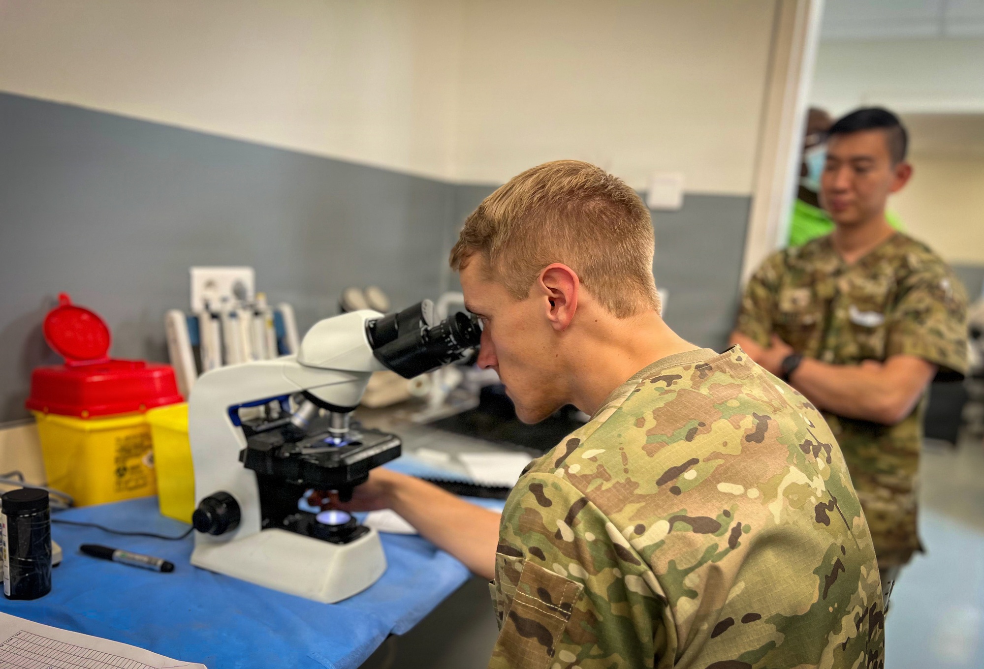 US Army Reserve medic examines malaria sample during medical readiness exercise