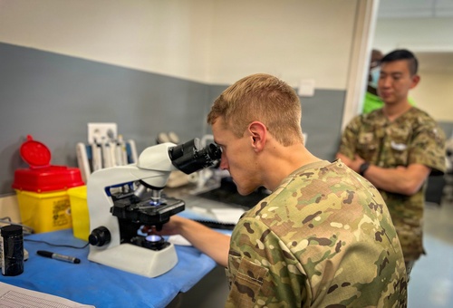 US Army Reserve medic examines malaria sample during medical readiness exercise